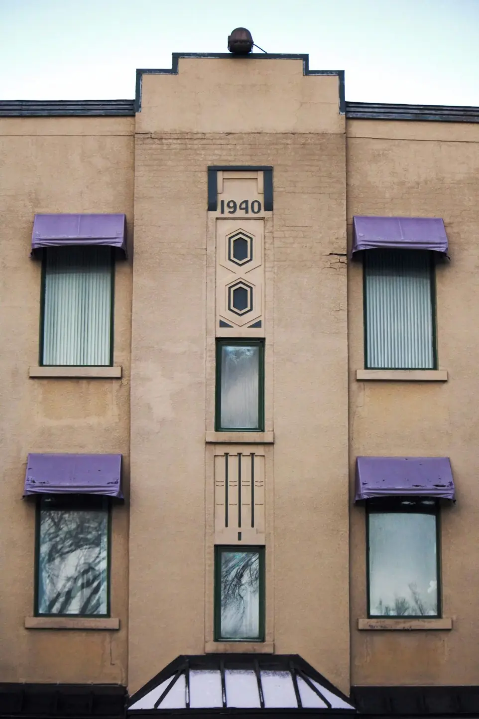 a tall building with purple awnings and windows